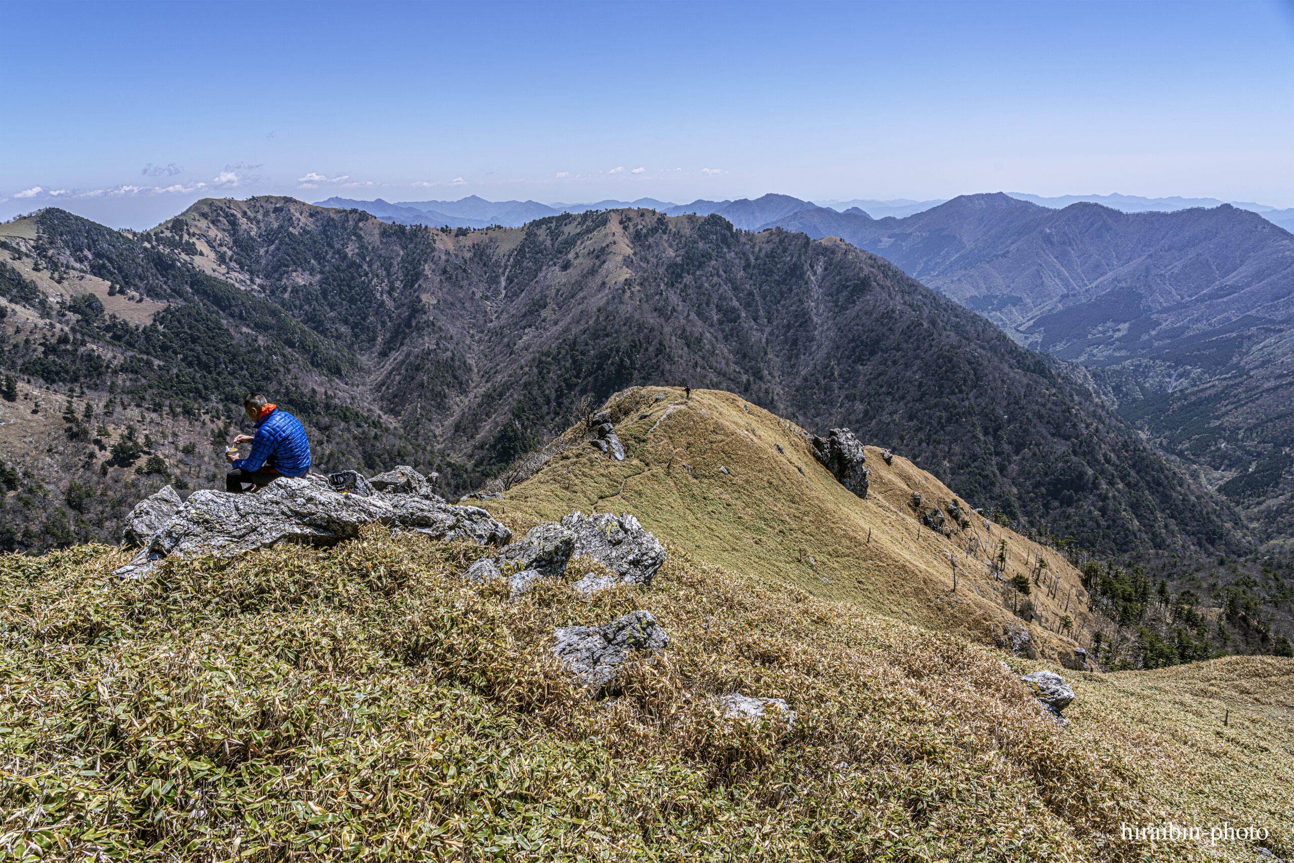 山頂を過ぎて、さらに進んだところ。向こう側から登ってくる登山者が見える。この方、中年の女性でした。左に見えるお昼を食べている登山者に声をかけ、話が弾んでいました。